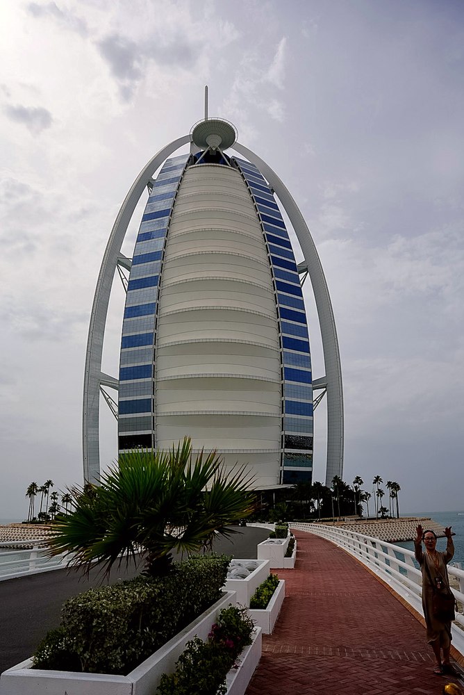 The sail-shaped Burj Al Arab hotel in Dubai, seen from the palm-lined approach road