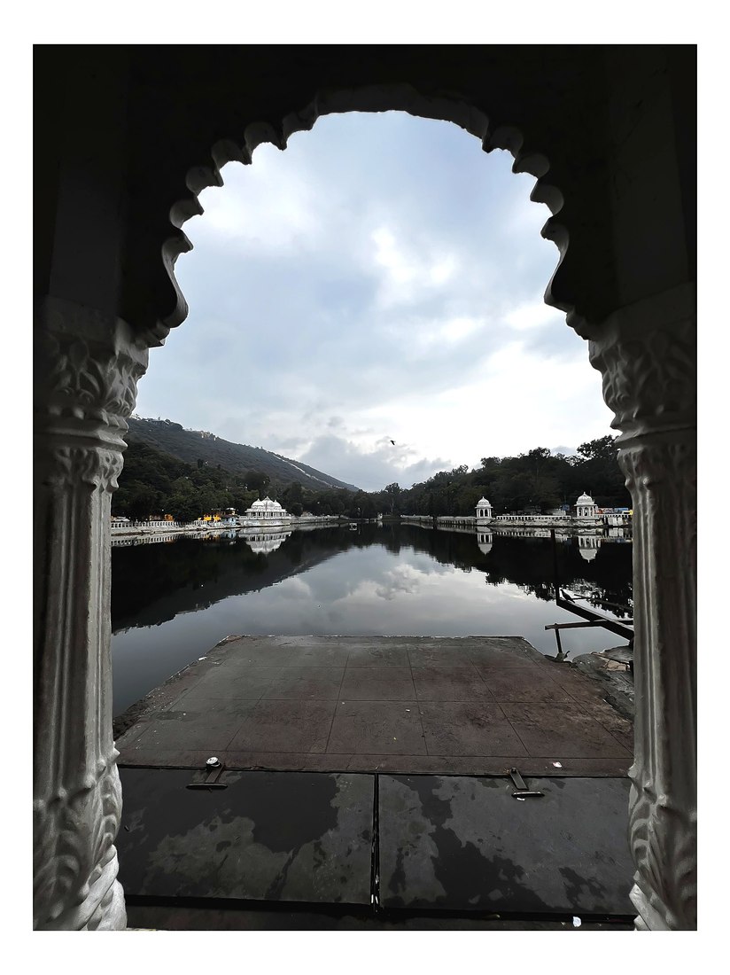The lake at Udaipur seen through a carved stone arch